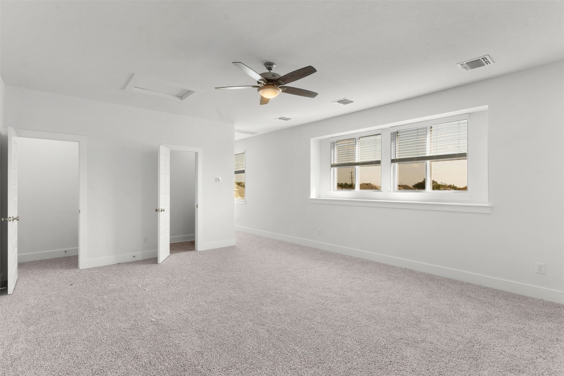 333 Ridgewell Loop Georgetown, TX 78633 - Photo 19 of 29 Unfurnished bedroom with attic access, light carpet, and a ceiling fan