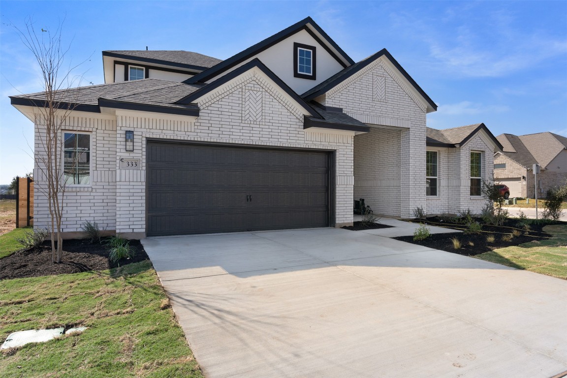 333 Ridgewell Loop Georgetown, TX 78633 - Photo 2 of 29 View of front of home featuring driveway, brick siding, an attached garage, and a shingled roof