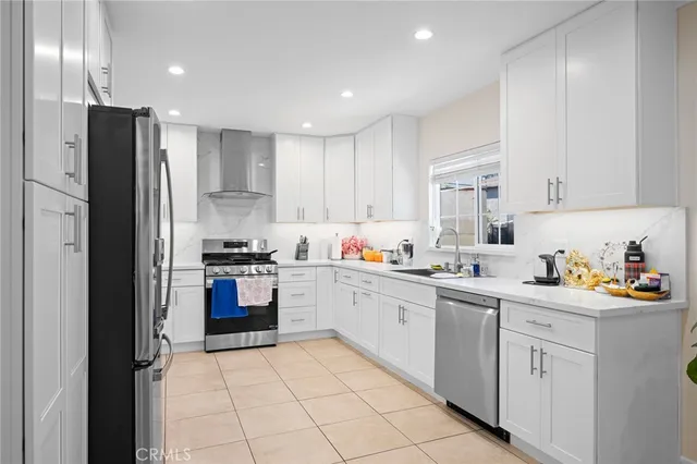 a kitchen with stainless steel appliances granite countertop a refrigerator and a stove top oven