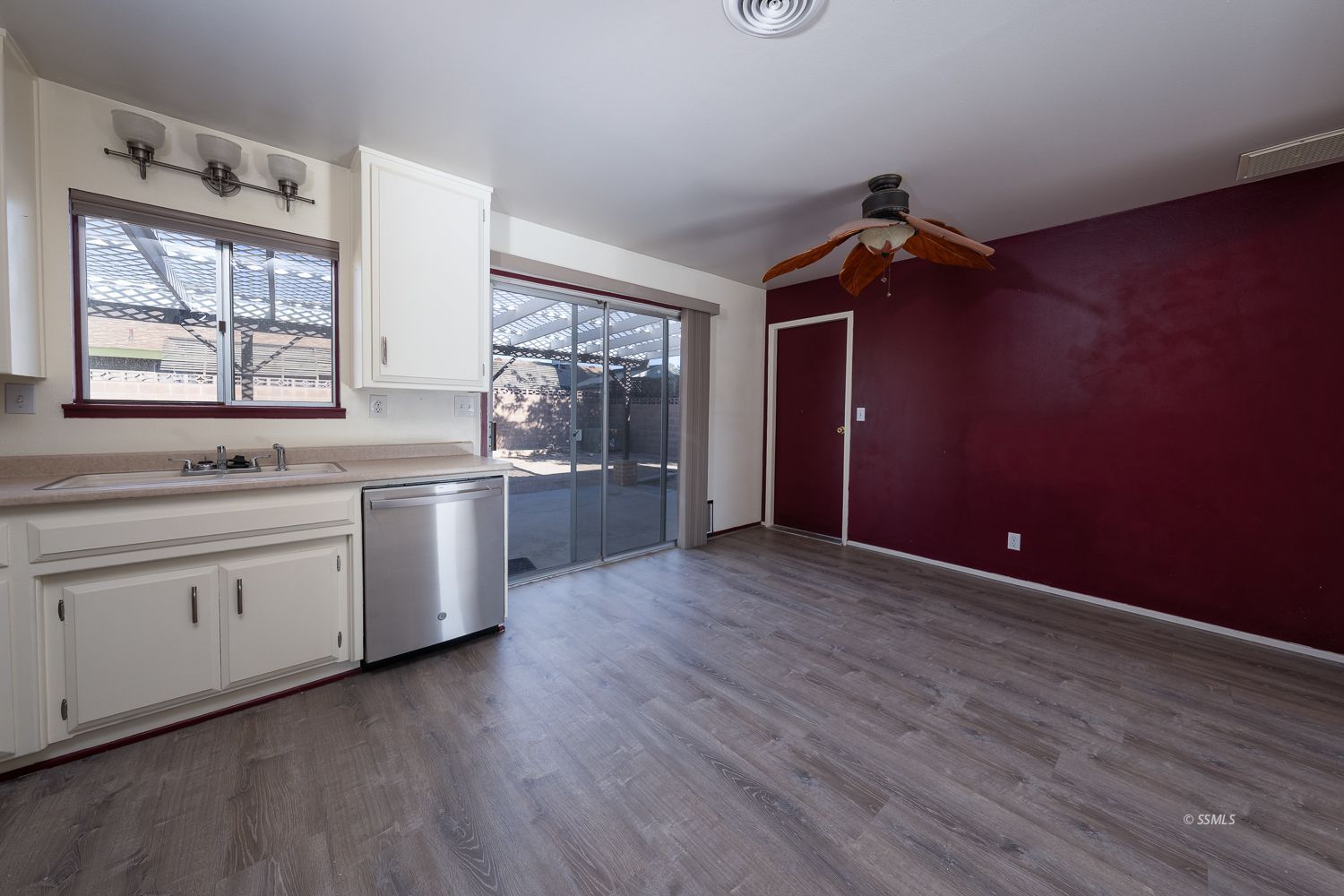 309 Mari Court Ridgecrest, CA 93555 - Photo 9 of 32 a kitchen with white cabinets and wooden floor