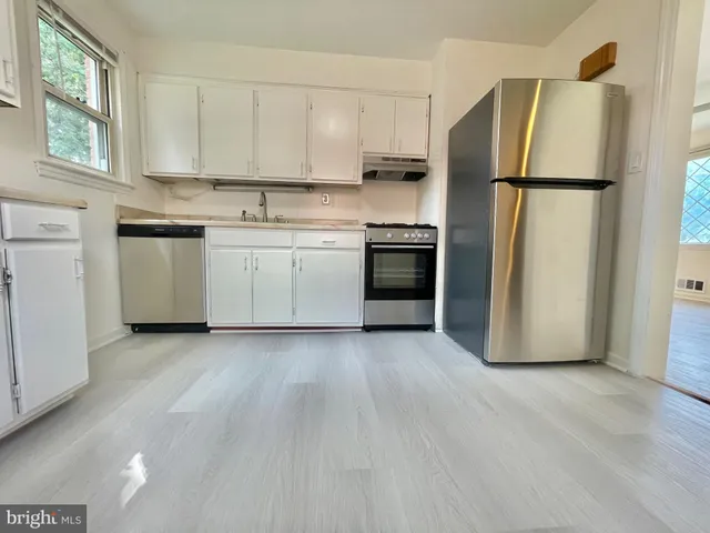 a kitchen with a refrigerator sink stove and cabinets