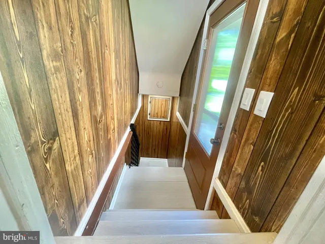 a view of a hallway with wooden floor and stairs