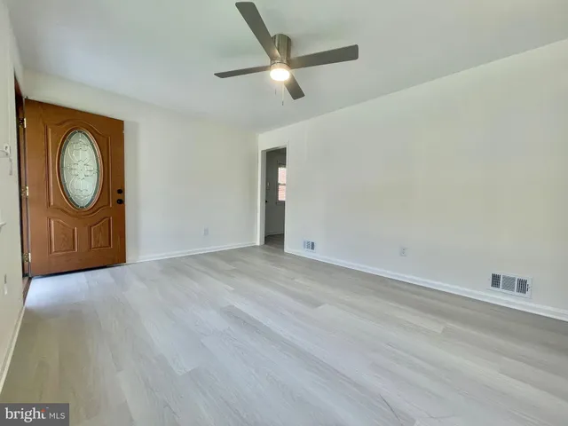a view of a livingroom with wooden floor and a ceiling fan