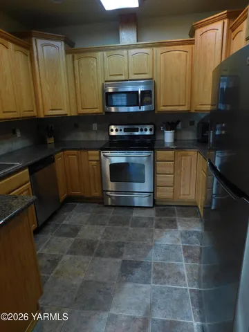 a kitchen with a stove a microwave and cabinets