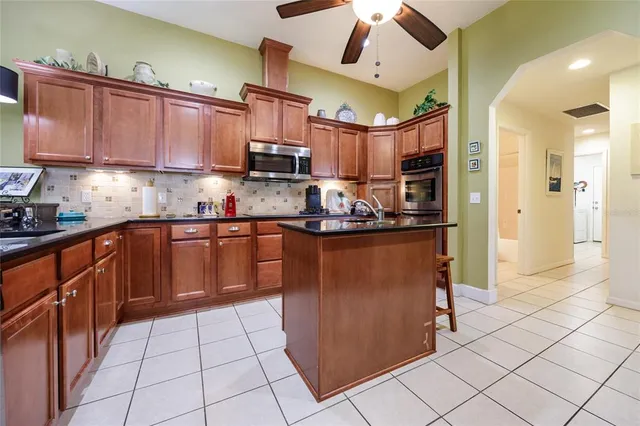 a kitchen with stainless steel appliances granite countertop a refrigerator a sink and a stove