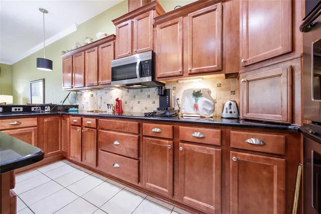 a kitchen with stainless steel appliances granite countertop a sink stove microwave and cabinets