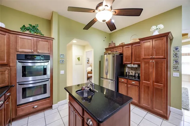 a kitchen with stainless steel appliances granite countertop a refrigerator a stove and a sink