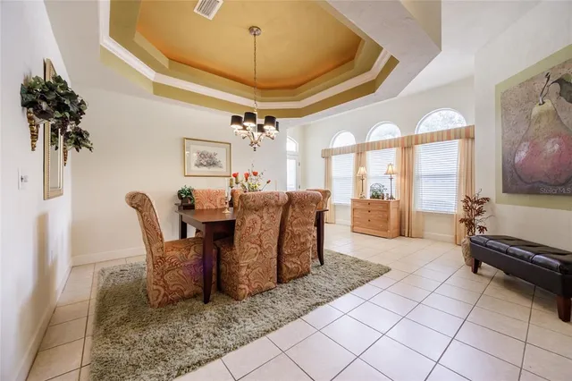 a living room with furniture a chandelier and a dining table