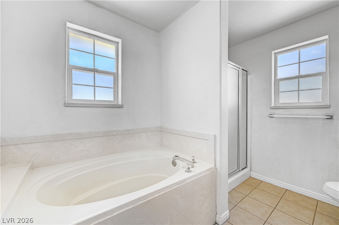 1272 Liston Avenue Logandale, NV 89021 - Photo 38 of 61 A spacious primary bathroom offers a generous soaking tub and separate glass-enclosed shower.