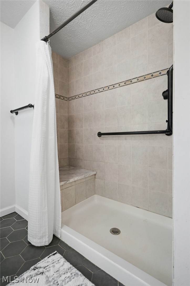 8160 Joyce Road Broadview Heights, OH 44147 - Photo 24 of 45 Shower stall featuring a tiled surround with decorative accent band, built-in bench, and black hardware