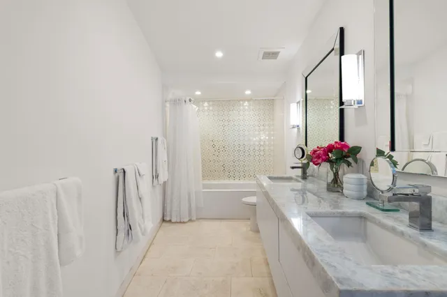 a bathroom with a granite countertop sink a toilet and a bathtub