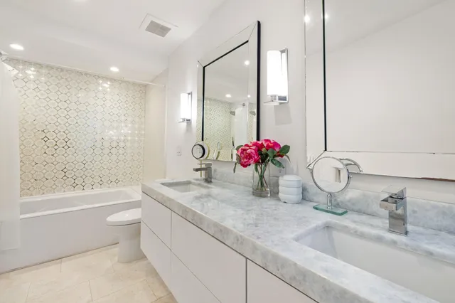 a bathroom with a granite countertop sink a toilet and shower