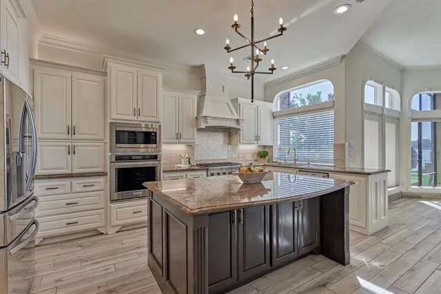 a kitchen with stainless steel appliances granite countertop a stove oven and a refrigerator