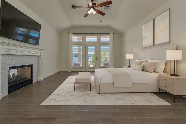 a large white bed in a living room with a fireplace