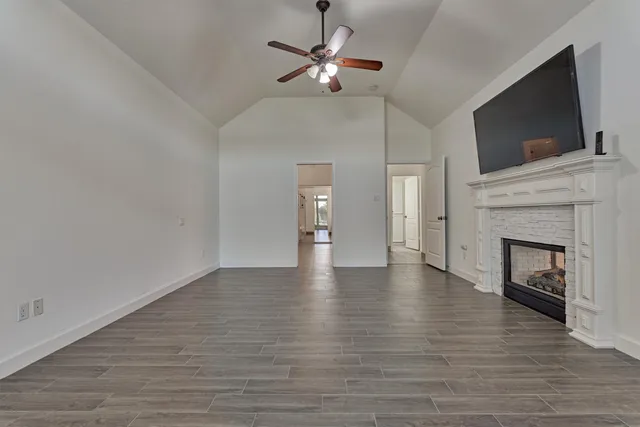 a view of an empty room with a fireplace and a flat screen tv