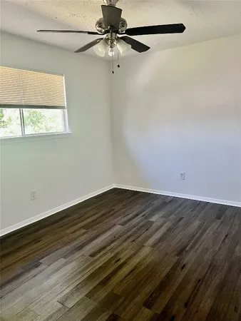 a view of a room with wooden floor and a ceiling fan
