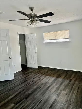 a view of a livingroom with wooden floor and a ceiling fan
