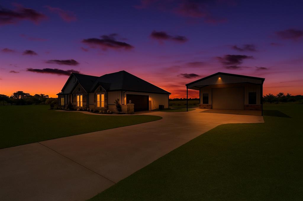View of front of property featuring a yard and a detached garage