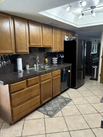 a kitchen with stainless steel appliances kitchen island granite countertop a refrigerator and a sink