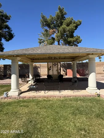 a view of a house with backyard and sitting area