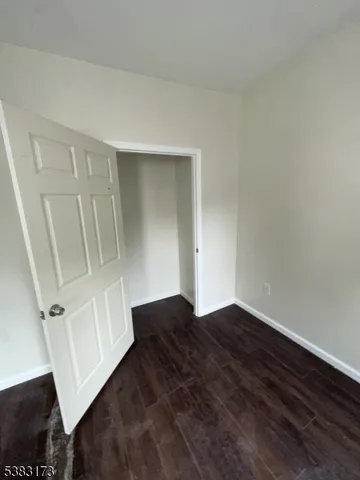 an empty room with wooden floor and white wall