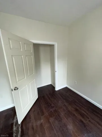 an empty room with wooden floor and white wall
