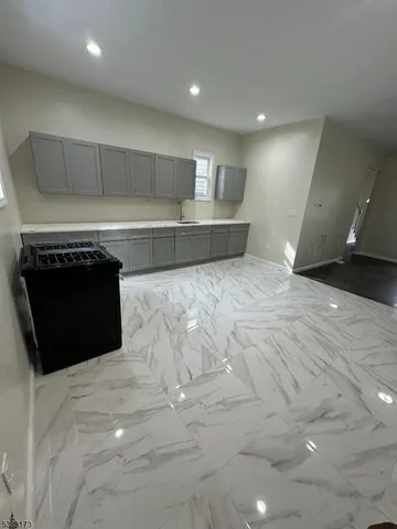 a view of kitchen and empty room with fireplace