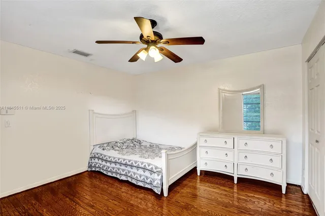 a view of a livingroom with wooden floor and a ceiling fan