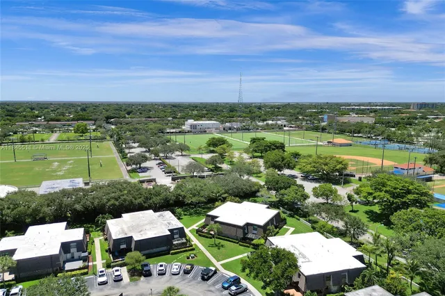 an aerial view of residential houses with outdoor space and a swimming pool