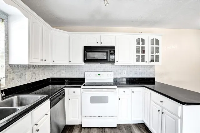 a kitchen with white cabinets and white appliances