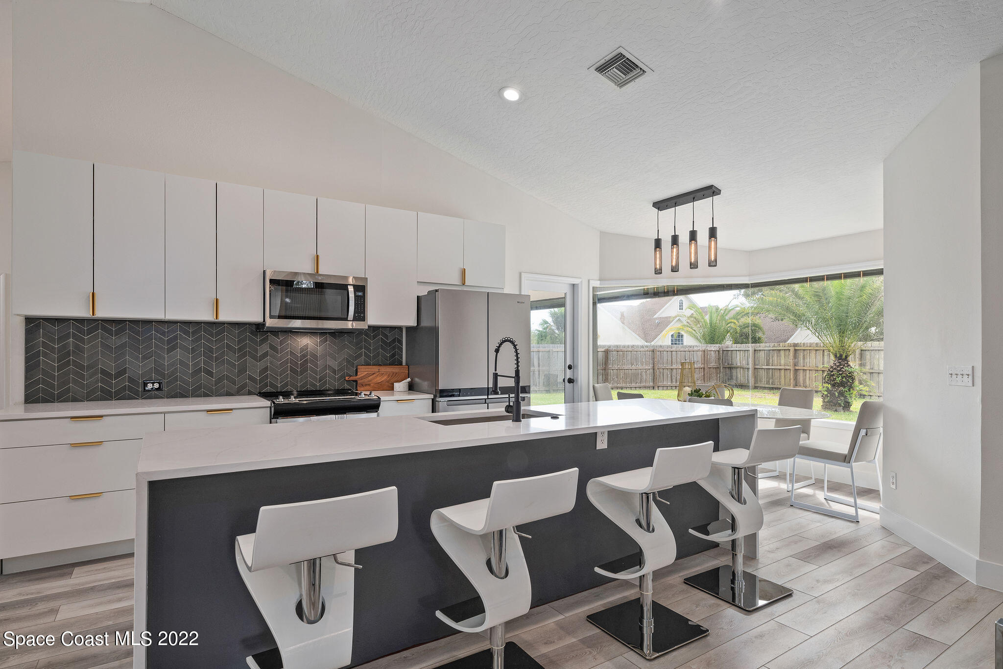 960 Falls Trail Malabar, FL 32950 - Photo 11 of 70 a kitchen with a dining table chairs and a sink