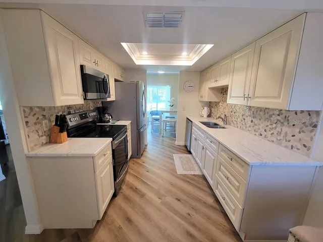 a kitchen with a sink a stove top oven a counter space and cabinets