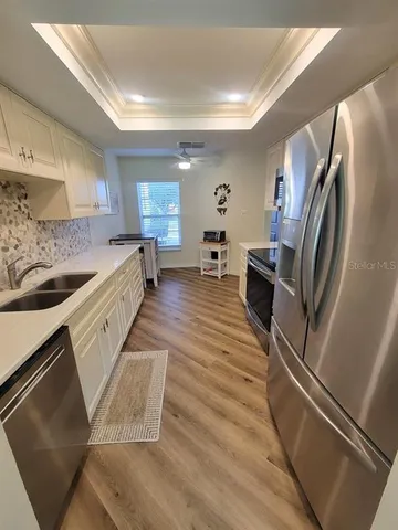 a kitchen with granite countertop a refrigerator stove and sink