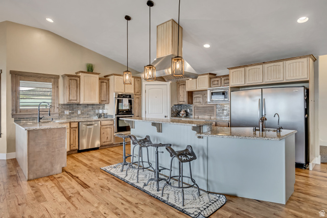 3054 West Ridgeline Road Stockton, UT 84071 - Photo 36 of 88 Kitchen featuring a kitchen breakfast bar, light stone countertops, tasteful backsplash, a large island, and lofted ceiling