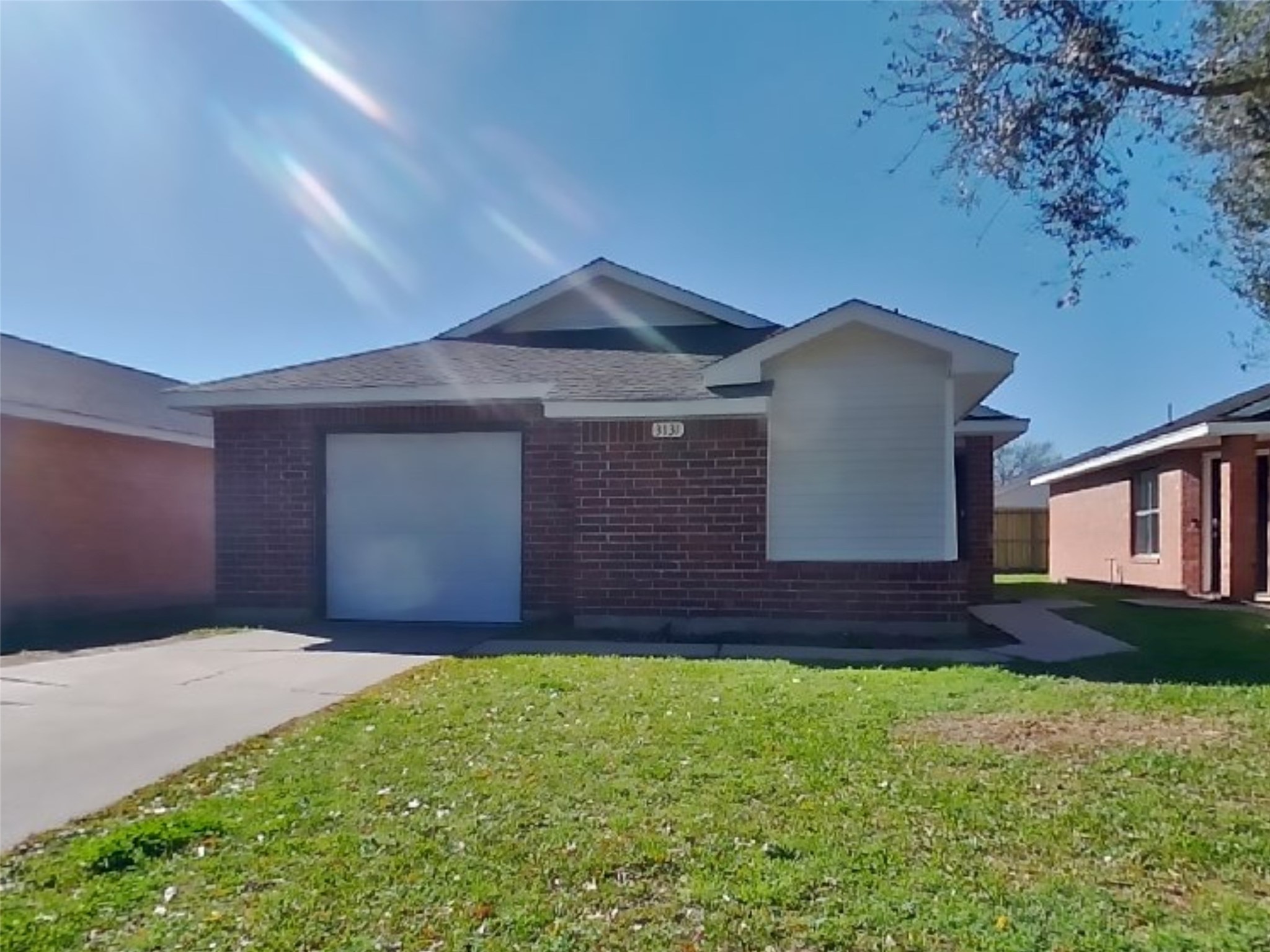 a front view of a house with a yard and wooden fence