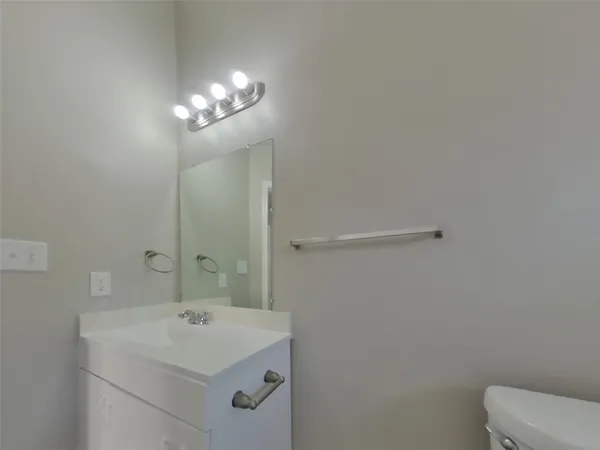 a bathroom with a sink a toilet and a mirror