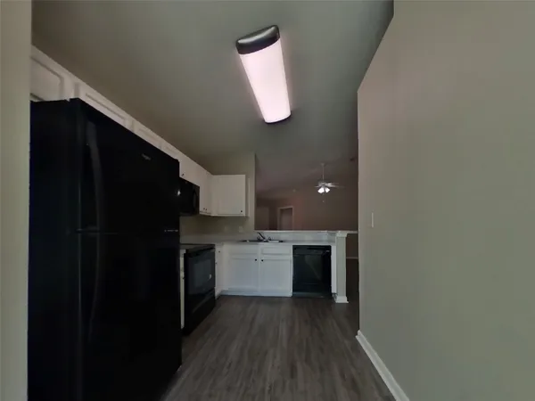 a kitchen with a refrigerator and a stove top oven