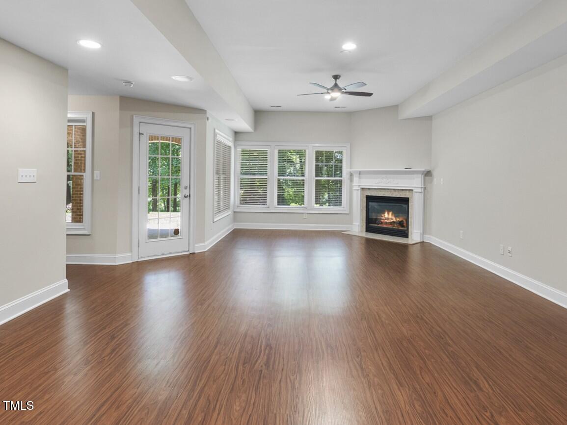 12257 Beestone Lane Raleigh, NC 27614 - Photo 38 of 59 an empty room with wooden floor fireplace and windows
