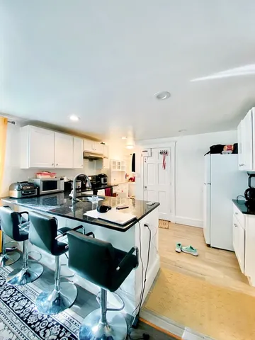 a kitchen with a sink and chairs
