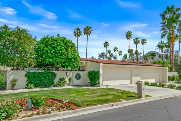 a view of a house with a yard and a garden