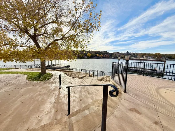 a view of a patio with couches and table and chairs with wooden floor and fence