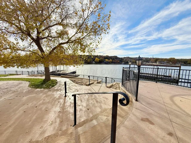 a view of a patio with couches and table and chairs with wooden floor and fence