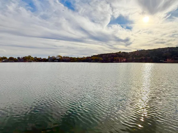 a kitchen with stainless steel appliances granite countertop a sink a stove and a wooden floors