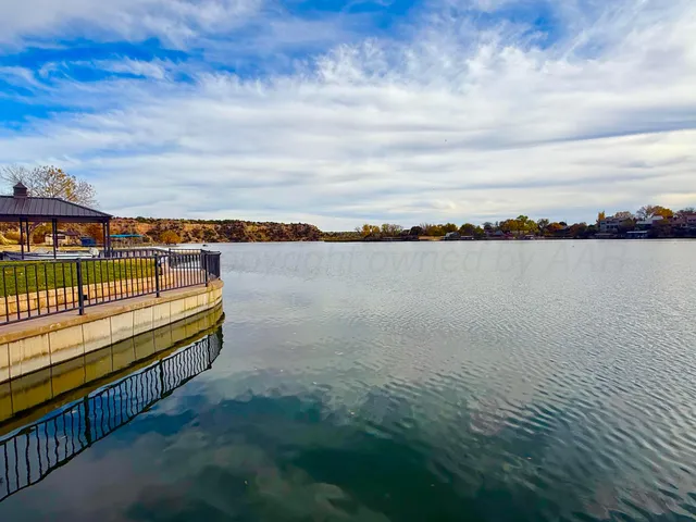 a kitchen with stainless steel appliances granite countertop a sink counter space cabinets and a wooden floor