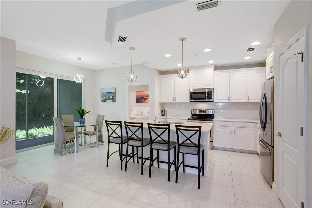 a kitchen with kitchen island wooden cabinets and refrigerator