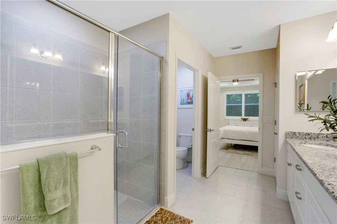 2343 Sheen Lane, Unit 401 Naples, FL 34120 - Photo 12 of 40 a en suite bathroom with a granite countertop sink a mirror and shower