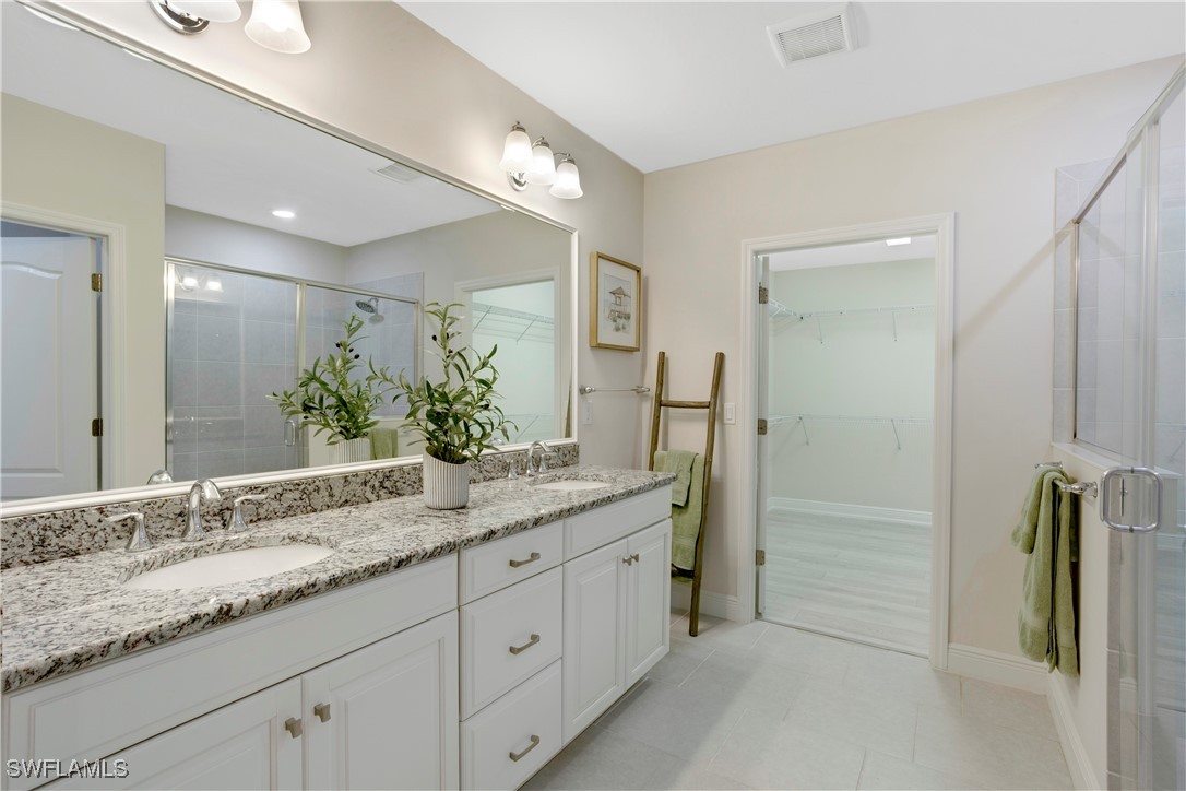 2343 Sheen Lane, Unit 401 Naples, FL 34120 - Photo 13 of 40 a bathroom with a granite countertop sink and a mirror
