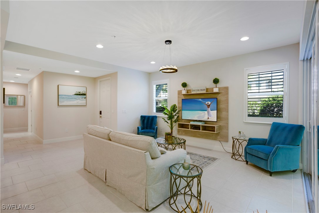 2343 Sheen Lane, Unit 401 Naples, FL 34120 - Photo 2 of 40 a living room with furniture and a flat screen tv