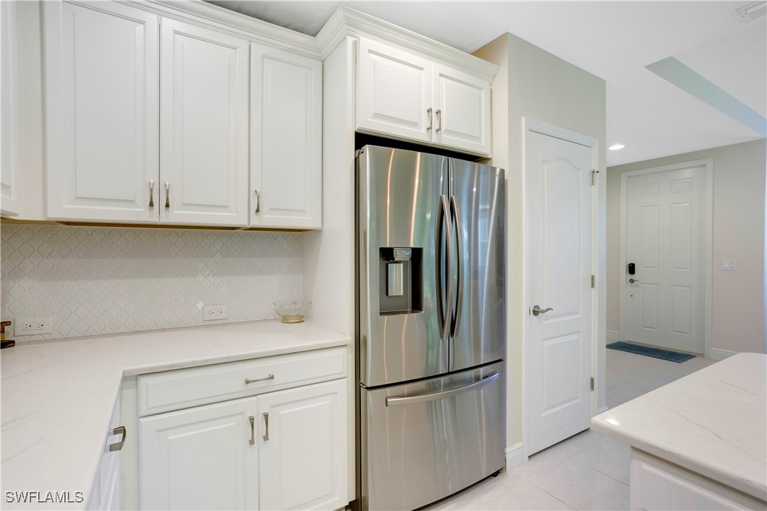 2343 Sheen Lane, Unit 401 Naples, FL 34120 - Photo 5 of 40 a kitchen with stainless steel appliances white cabinets and a refrigerator
