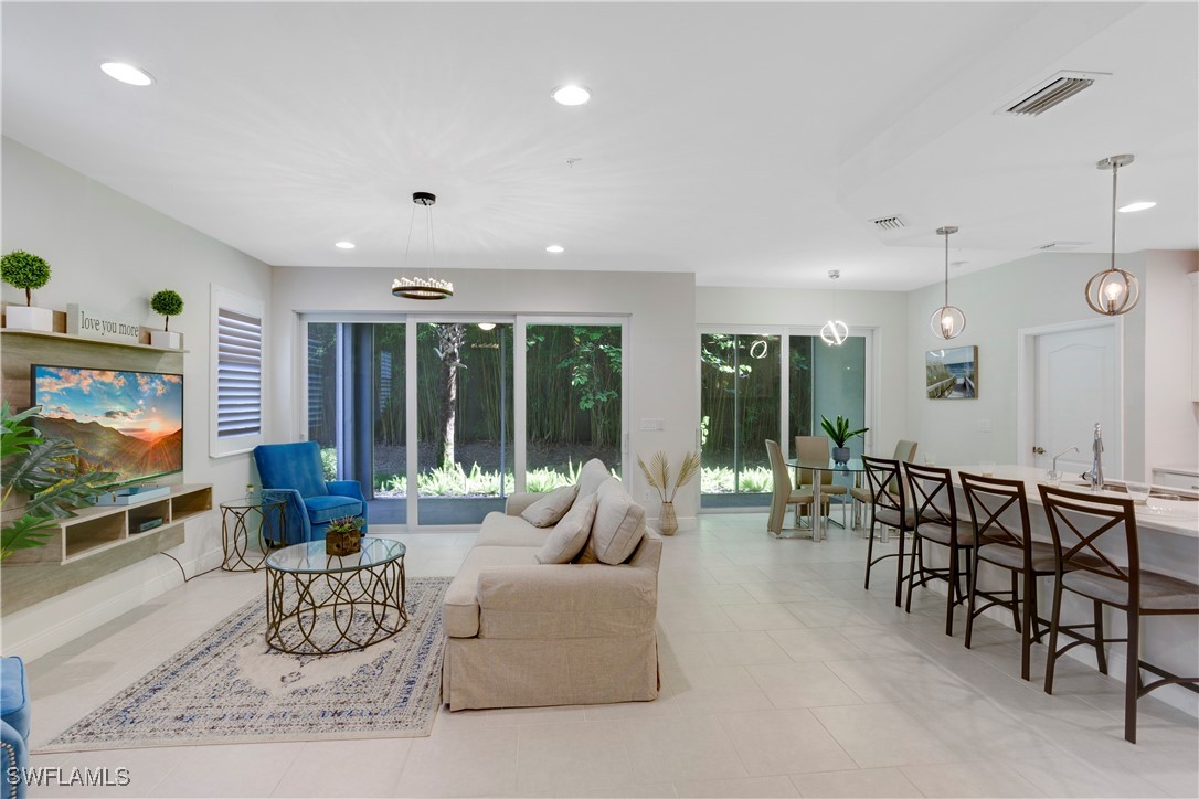 2343 Sheen Lane, Unit 401 Naples, FL 34120 - Photo 8 of 40 a living room with furniture and a flat screen tv